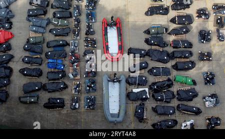 Une vue de petits bateaux et moteurs utilisés pour traverser la Manche par des personnes considérées comme des migrants dans un entrepôt à Douvres, Kent. Date de la photo : lundi 2 octobre 2023. Banque D'Images