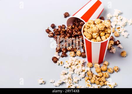 Assortiment de pop-corn dans une tasse rouge blanche rayée en papier. Pop-corn sucré et salé Banque D'Images