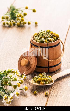 Petit tonneau en bois avec des fleurs sèches de camomille et bouquet de fraîches Banque D'Images