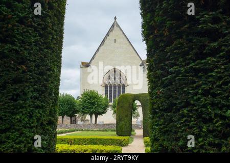 Angers, France, 2023. La chapelle du 15e siècle des logements royaux vue à travers l'arc d'une tonnelle d'if dans le jardin formel Banque D'Images