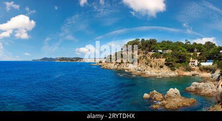 Mer d'été vue sur la côte rocheuse (près de Lloret de Mar, Catalogne, Espagne). Personnes méconnaissables. Banque D'Images