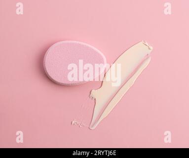 Éponge cosmétique en forme d'œuf sur fond rose. Vue de dessus Banque D'Images