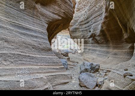 Les murs rugueux et altérés d'un tunnel rocheux avec de minuscules crevasses et des fentes étroites dans la surface Banque D'Images