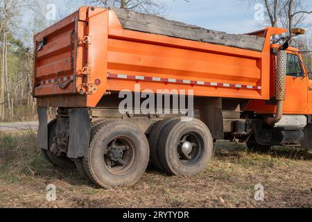 Un vieux gravier orange bien utilisé ou une caisse de camion à benne basculante, vue du coin arrière. Banque D'Images