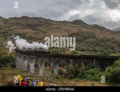 Glenfinnan, Écosse, lundi 2 octobre 2023, le train à vapeur jacobite, également connu sous le nom de Poudlard Express, présenté dans les films Harry Potter, passe au-dessus du viaduc de Glenfinnan sur la Highland Line ouest, sous le regard des foules de spectateurs. Crédit : LU Parrott/ Alamy Live News Banque D'Images