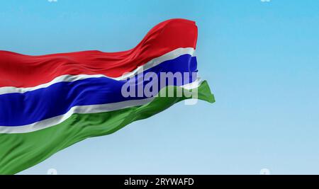 Drapeau national de la Gambie agitant dans le vent par temps clair. Trois bandes horizontales rouges, bleues et vertes, séparées par deux bandes blanches étroites. 3d il Banque D'Images