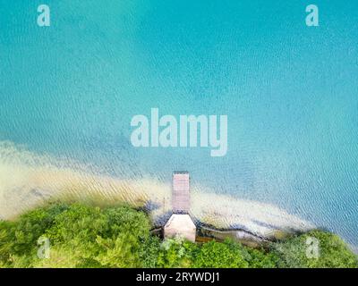 Vue aérienne de la belle jetée en bois, mer ou baie du lac, plage de sable au coucher du soleil en été. Vue de dessus de la jetée, wate bleu transparent Banque D'Images