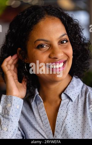 Portrait d'heureuse femme d'affaires occasionnelle biracial dans le bureau. Bureau décontracté, affaires, style de vie et travail, inchangé. Banque D'Images