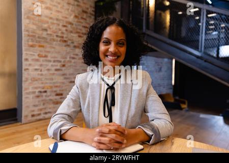 Portrait d'heureuse femme d'affaires occasionnelle biracial dans le bureau. Bureau décontracté, affaires, style de vie et travail, inchangé. Banque D'Images