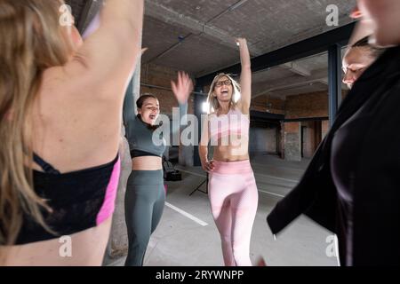 Groupe de jeunes femmes acclamant après l'entraînement en tenue sportive Banque D'Images