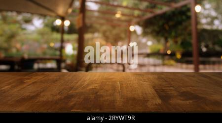 Image de la table en bois devant le fond flou abstrait des lumières de jardin extérieures. peut être utilisé pour l'affichage ou le montage de votre Banque D'Images