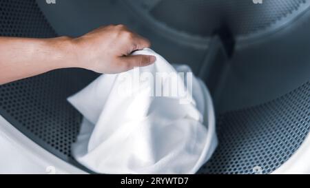 Mari de la maison avec panier et vêtements sales ou lavés à laundryÂ intérieur de la buanderie. lavage machineÂ à l'entreprise de blanchisserie stor Banque D'Images