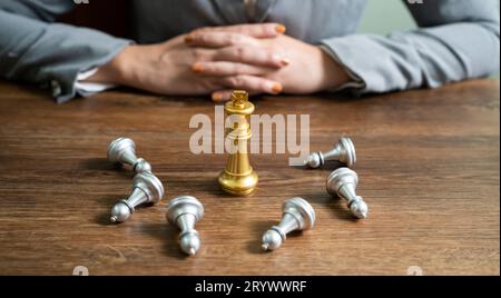 Concept de victoire de leadership d'échecs avec goldÂ vainqueur stand alone avec des pièces d'échecs en argent déchues King gagne le jeu décision et Banque D'Images