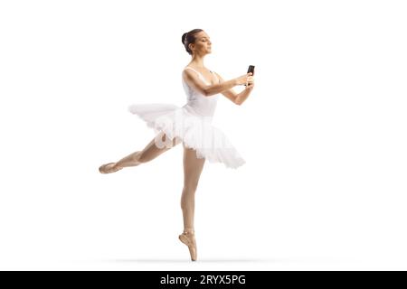 Plan complet d'une ballerine dansant et tenant un smartphone isolé sur fond blanc Banque D'Images