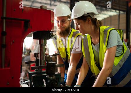 Les deux ingénieurs mécaniques vérifient l'état de fonctionnement de la nouvelle machine après avoir terminé l'installation Banque D'Images