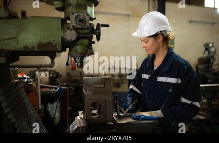 Portrait des ingénieurs mécaniciens vérifient l'état de fonctionnement d'une vieille machine qui a été utilisée pendant un certain temps. Dans une fac Banque D'Images