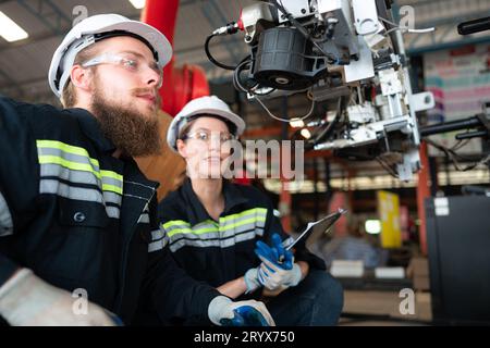 Ingénieur électricien avec la mission d'installer un système électrique de bras robotisé Banque D'Images