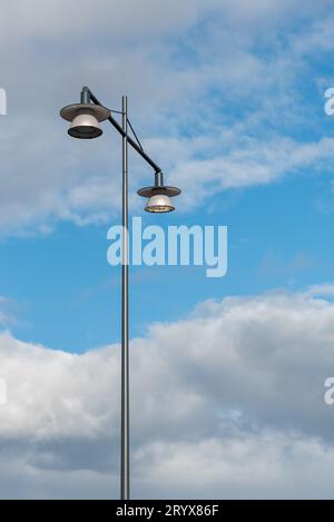 Lampadaire de lampadaire contre le ciel nuageux bleu. Lumière dans les rues Banque D'Images