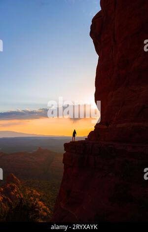 Silhouette d'une femme sur le sentier à Cathedral Rock au coucher du soleil à Sedona. Le coucher de soleil coloré sur le site Cathedral Rock de Sedona Banque D'Images