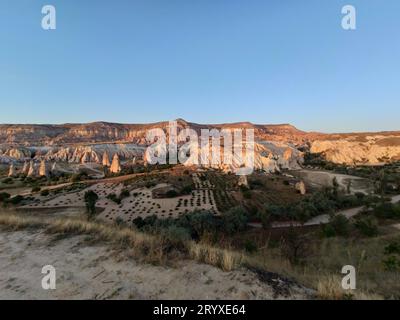 Vue en grand angle d'une vallée avec des collines de grès au coucher du soleil près de Goreme en Cappadoce, Turquie Banque D'Images