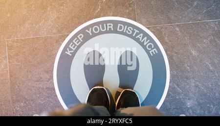 Inscription de distanciation sociale sur le sol du supermarché. Gardez des distances dans la société publique pour protéger COVID-19 Banque D'Images