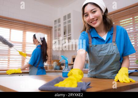 Portrait de jeune femme asiatique nettoyant la table dans la cuisine à la maison Banque D'Images