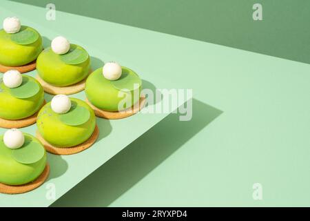 Un plateau de beignets verts assortis est posé sur une table en bois Banque D'Images