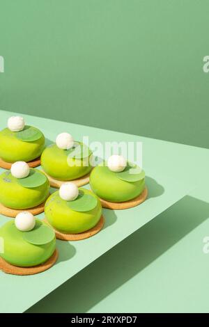 Un plateau de beignets verts assortis est posé sur une table en bois Banque D'Images