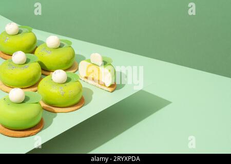 Un plateau de beignets verts assortis est posé sur une table en bois Banque D'Images