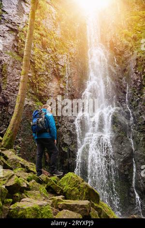 Tourist attraction of Germany - falls of Burgbach Waterfall near Schapbach, Black Forest, Baden-Wurttemberg, Germany. Man hiker Banque D'Images