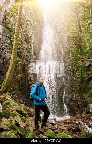 Tourist attraction of Germany - falls of Burgbach Waterfall near Schapbach, Black Forest, Baden-Wurttemberg, Germany. Man hiker Banque D'Images
