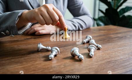 Concept de victoire de leadership d'échecs avec goldÂ vainqueur stand alone avec des pièces d'échecs en argent déchues King gagne le jeu décision et Banque D'Images