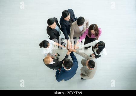 Vue de dessus du groupe de gens d'affaires joignant les mains ensemble dans le bureau pour s'autonomiser mutuellement Banque D'Images