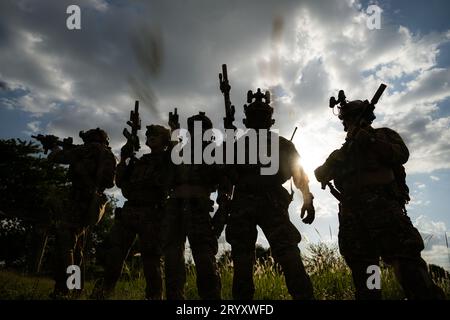 Soldat tenant une arme à feu et montrant le succès de l'action ou la victoire de guerre, concept de formation militaire des forces spéciales. Banque D'Images