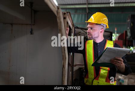 L'ingénieur inspecte le système électrique et répare le système mécanique dans l'armoire de commande de la machine. pour le m Banque D'Images