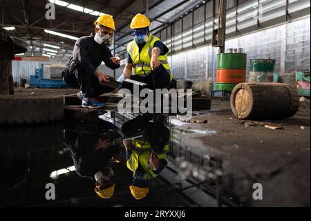 Les scientifiques et les représentants du gouvernement inspectent et recueillent des échantillons de fuites chimiques dans les sites industriels. faire l'objet d'une enquête approfondie Banque D'Images