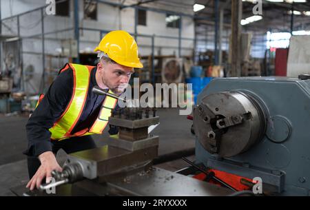 Les ingénieurs mécaniciens entrent dans l'ancien entrepôt de machines pour inspecter et réparer les machines usagées avec le personnel de l'entrepôt. Banque D'Images