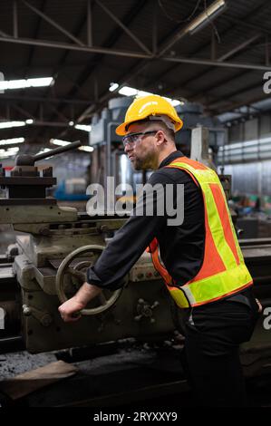 Les ingénieurs mécaniciens entrent dans l'ancien entrepôt de machines pour inspecter et réparer les machines usagées avec le personnel de l'entrepôt. Banque D'Images