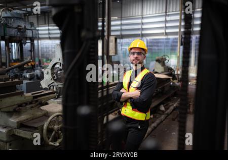 Les ingénieurs mécaniciens entrent dans l'ancien entrepôt de machines pour inspecter et réparer les machines usagées avec le personnel de l'entrepôt. Banque D'Images