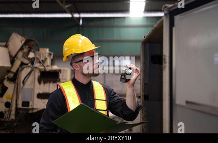 L'ingénieur inspecte le système électrique et répare le système mécanique dans l'armoire de commande de la machine. pour le m Banque D'Images