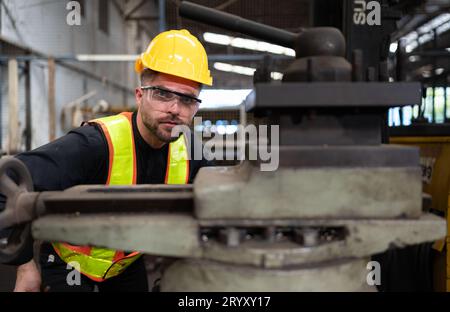 Les ingénieurs mécaniciens entrent dans l'ancien entrepôt de machines pour inspecter et réparer les machines usagées avec le personnel de l'entrepôt. Banque D'Images