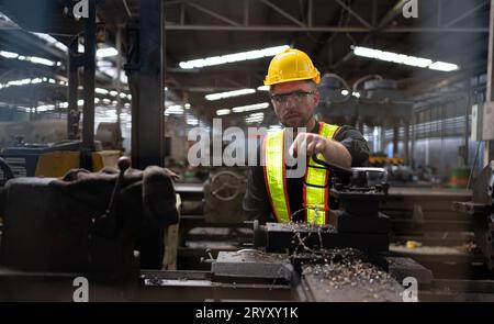 Les ingénieurs mécaniciens entrent dans l'ancien entrepôt de machines pour inspecter et réparer les machines usagées avec le personnel de l'entrepôt. Banque D'Images