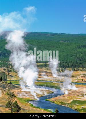 L'augmentation de vapeur à partir de hot springs le long de la rivière firehole dans le parc national de Yellowstone, Wyoming Banque D'Images