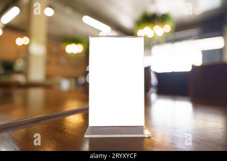 Cadre de menu de maquette debout sur une table en bois dans le bar-restaurant café. espace pour le texte. MenuÂ mack up blanc pour la promo de marketing de texte Banque D'Images
