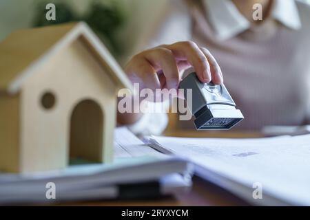 Timbre approuvé avec les gens d'affaires signant le contrat faisant affaire avec le consultant immobilier d'assurance habitation investissement immobilier Banque D'Images