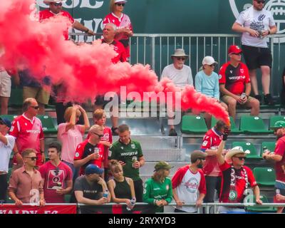 Calgary, Alberta, Canada. 17 juillet 2023. Un fan de football tenant une bombe fumigène de couleur pendant un match. Concept : passion des fans, foules Banque D'Images