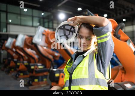 Portrait de femme ingénieur avec la mission d'auditer, tester, améliorer les logiciels et calibrer le bras robotique. Banque D'Images