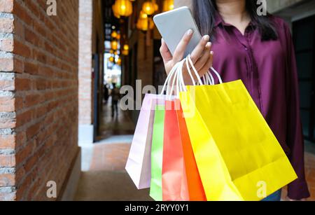 Filles asiatiques tenant des sacs à provisions en solde. concept de style de vie consumérisme dans le centre commercial. lady tourist walk centre commercial wi Banque D'Images