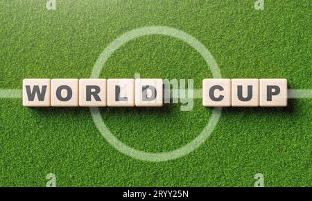 Alphabet de mot de coupe du monde sur le cube de bloc en bois dans le terrain de football avec la ligne centrale. Sport et concept de tournoi. Illustration 3D ren Banque D'Images