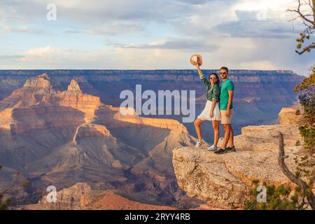 Couple heureux sur une falaise escarpée en profitant de la vue imprenable sur le célèbre Grand Canyon sur un magnifique coucher de soleil, Grand Canyon National P Banque D'Images